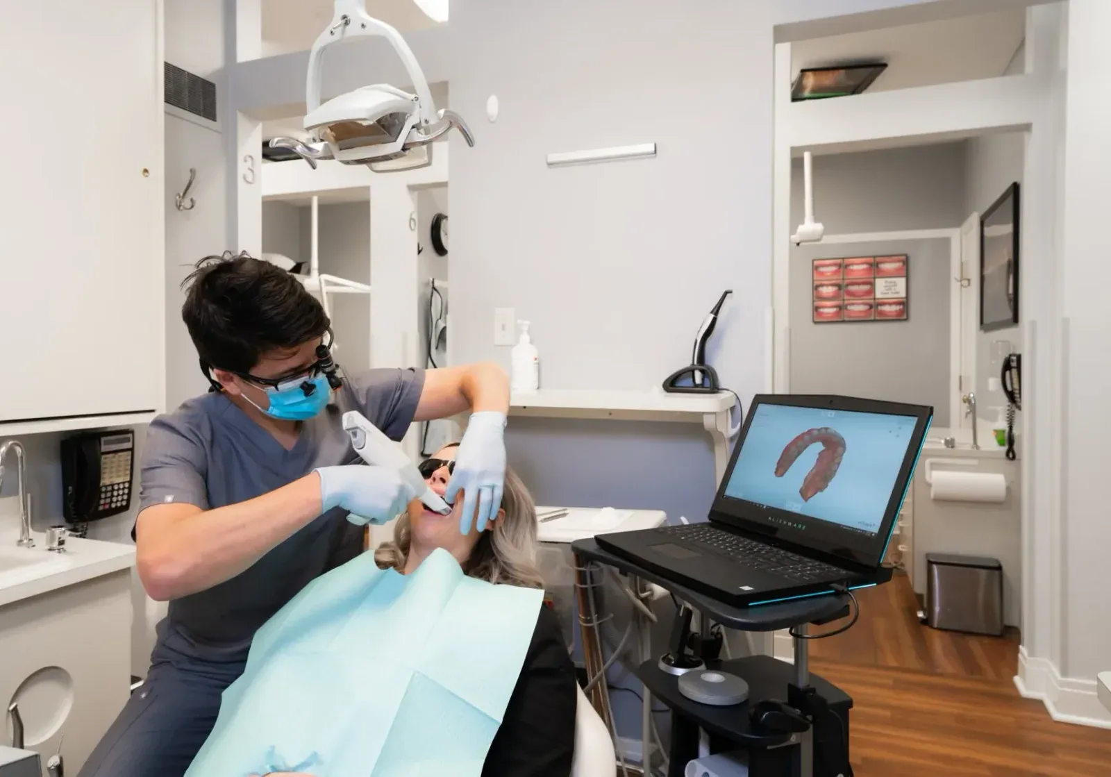 Intraoral scanning during a dental visit, with a digital model visible on the screen