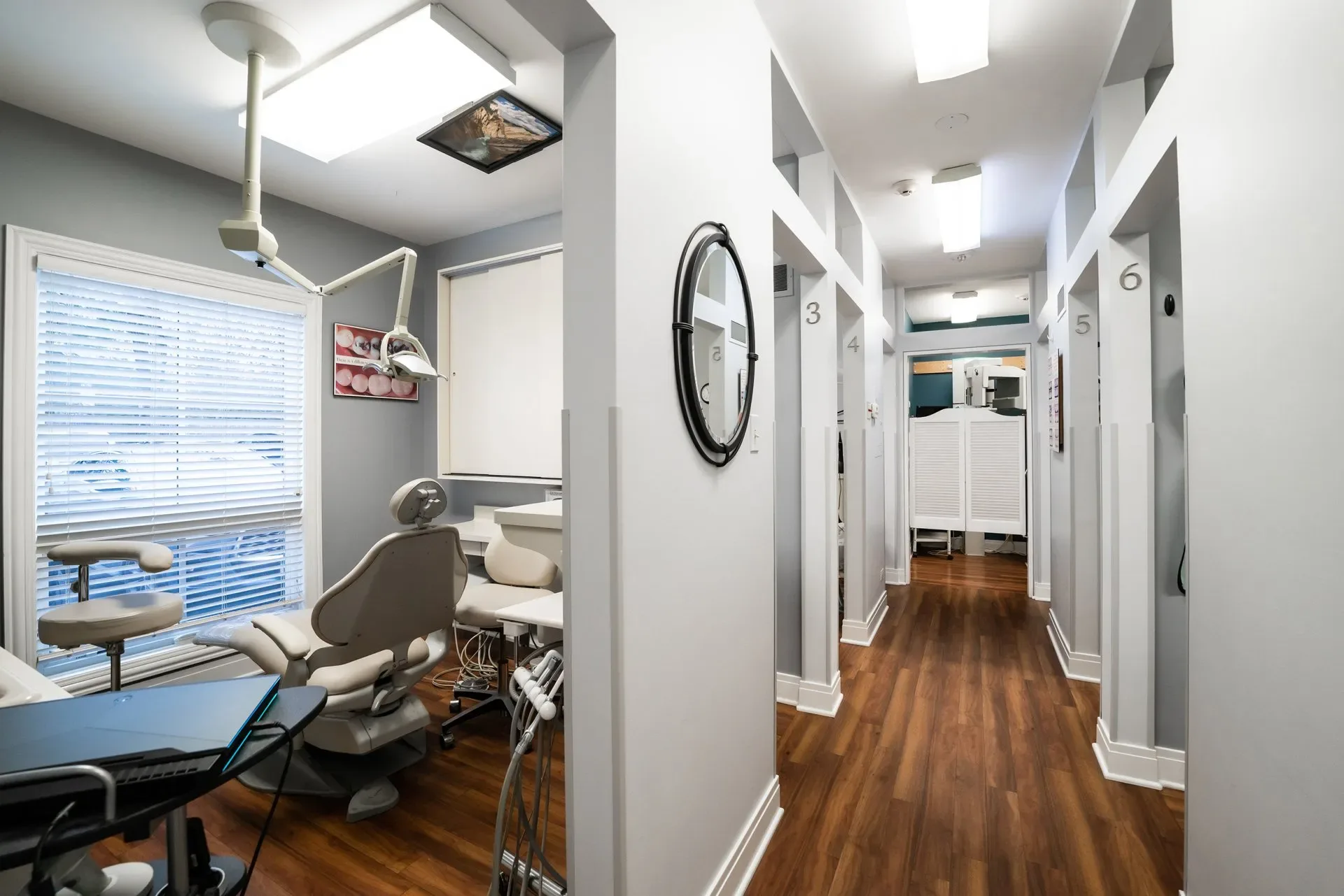 Bright treatment rooms and a wood-floored hallway inside the Lake Forest dental office