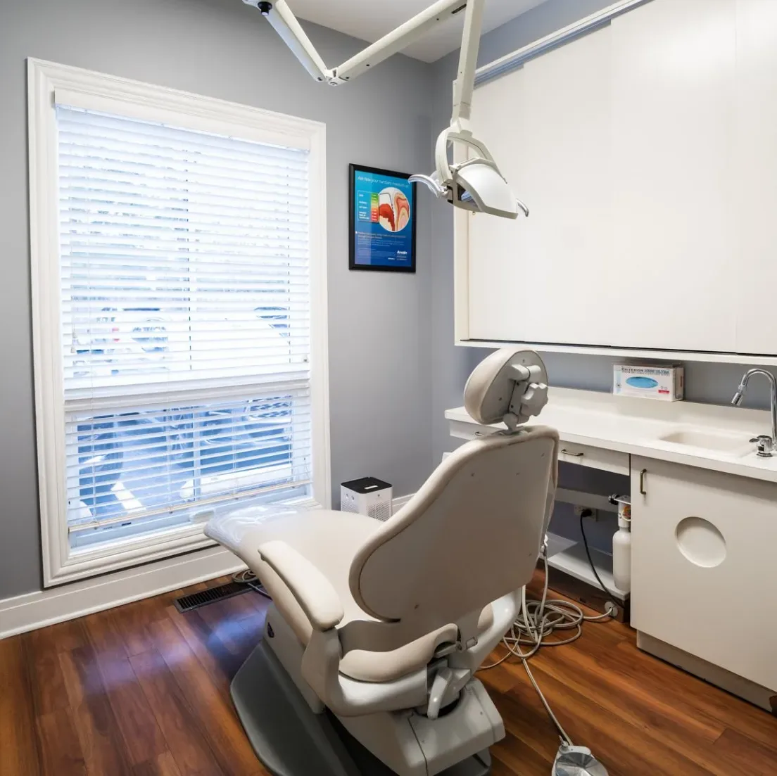 Sunlit dental treatment room with a dental chair and overhead examination light
